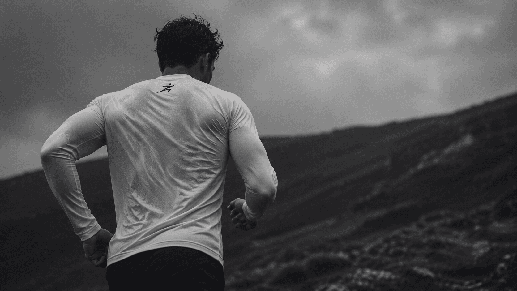 A Malin runner training on an exposed hillside under heavy cloud